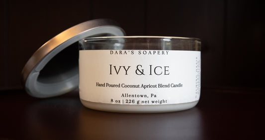Candle jar labeled 'Ivy & Ice' from Dara's Soapery on a dark background
